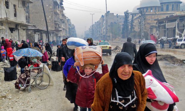 Syrian residents, fleeing violence in the restive Bustan al-Qasr neighbourhood, arrive in Aleppo's Fardos neighbourhood on December 13, 2016, after regime troops retook the area from rebel fighters. Syrian rebels withdrew from six more neighbourhoods in their one-time bastion of east Aleppo in the face of advancing government troops, the Syrian Observatory for Human Rights said. / AFP / STRINGER (Photo credit should read STRINGER/AFP/Getty Images) *** BESTPIX ***